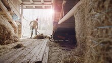 SLOW MOTION LENS FLARE - The Farmer Fluffs The Hay In An Old Rustic Barn