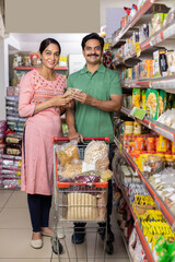 Wall Mural - Happy couple shopping for groceries at the supermarket