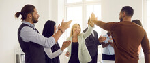 Happy Multiracial Business Team Celebrating Success. Smiling Young Man And Woman Give Each Other High Five While Office Colleagues Are Applauding. Successful Teamwork Concept. Banner Header Background
