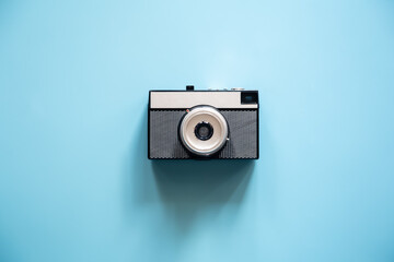 Wall Mural - Vintage retro camera on a blue background, flat lay.