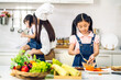 © Art_Photo - Portrait of enjoy happy love asian family mother and little asian girl daughter child having fun help cooking food healthy eat together with fresh vegetable salad and sandwich ingredient in kitchen