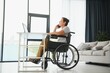 © Serhii - Middle age woman using laptop sitting on wheelchair at home