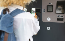 Woman Scanning QR Code On Ticket Vending Machine