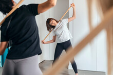 Fitness Instructor Teaching Stick Yoga In Health Club