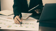 © Orathai - The businesswoman hand sits at their desks and calculates financial graphs showing the results of their investments planning the process of successful business growth