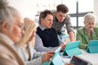 © Halfpoint - Group of seniors attending IT class in community centre with teacher