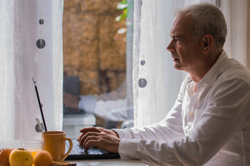 Wall Mural - adult man using pc while having breakfast at home