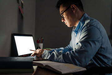 Wall Mural - Adult focused man in glasses working / studying with laptop