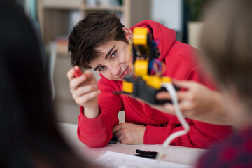 Wall Mural - group of students building and programming electric toys and robots at robotics classroom