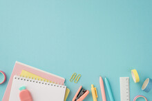 Back To School Concept. Top View Photo Of Colorful School Accessories Notepads Pineapple Shaped Eraser Ruler Adhesive Tape Pens Clips And Stapler On Isolated Pastel Blue Background With Empty Space
