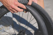 man holds a bicycle tube and a bike wheel in his hand in the process of repairing and refit bmx