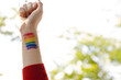© Wavebreak Media - Image of hand of caucasian non-binary trans woman with painted rainbow flag