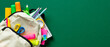© photoguns - Backpack with colorful school supplies on green background. Back to school sale banner design.