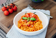 Served Plate Of Just Cooked Homemade Fettuccine Pasta With Creamy Tomato Sauce, Seafood And Parmesan Cheese, Decorated With Basil Leaves And Fresh Cherry Tomatoes On The Wooden Table. Selective Focus.