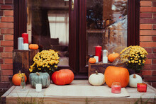 House Entrance Decorated For Traditional Autumn Holidays. Porch Of The House Decorated With Pumpkins, Flowers, And Candles For Thanksgiving Or Halloween. Selective Focus.