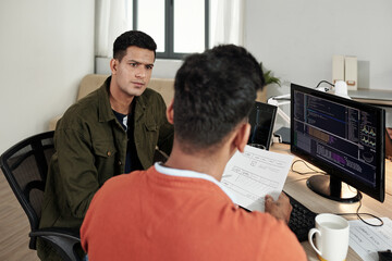 Wall Mural - serious software developer listening to ideas of front end developer at meeting