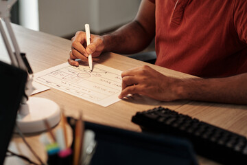 Wall Mural - hands of ui designer or front end developer drawing wireframe on paper sheet