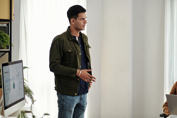 Wall Mural - young ambitious indian startup founder giving motivational speech in front of colleagues at meeting