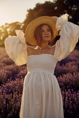 Wall Mural - the pregnant girl with a hat in the lavender field on a sunset