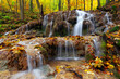 Small waterfall in beautiful autumn forest 