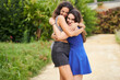 © Retamosa - Two smiling friends embrace after meeting in the park