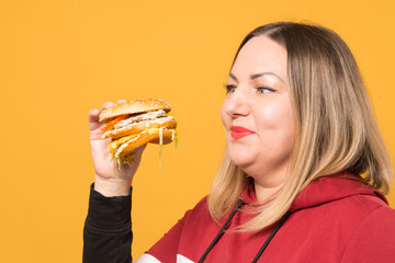 a hungry woman is biting a big tasty burger