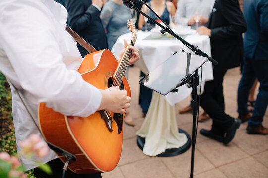 singer sings on the guitar outside at a wedding. wedding with live music. music for private events