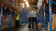 © kelvn - Warehouse manager talking and pointing towards shelf while checking product in warehouse, Logistic industry concept.