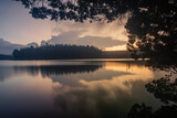 Fototapeta  - Serene view of a lake during sundown captured using long exposure with perfect reflection
