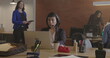 Office place with young people working at corporate job. Female staff wearing headset behind laptop computer