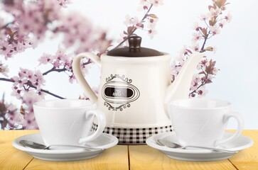 Wall Mural - Tea concept with white tea set of cups and teapot with fresh tea on the desk