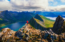 Hiker standing on the top of Husfjellet Mountain on Senja Island in Norway