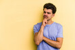 © Asier - Young caucasian man isolated on yellow background looking sideways with doubtful and skeptical expression.