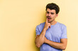 © Asier - Young caucasian man isolated on yellow background looking sideways with doubtful and skeptical expression.