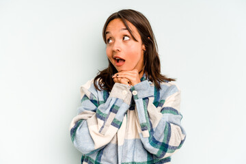 Wall Mural - Young hispanic woman isolated on blue background pointing upside with opened mouth.