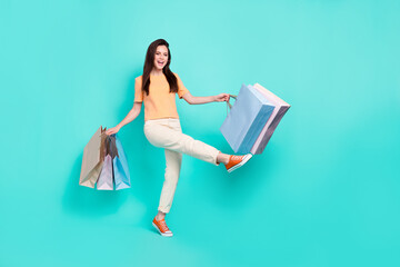 Poster - Full body portrait of cheerful crazy person hold packages holiday promo isolated on teal color background