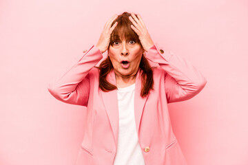 Wall Mural - Middle age caucasian woman isolated on pink background being shocked, she has remembered important meeting.