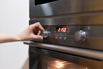 Person's hand dealing with oven timer setting