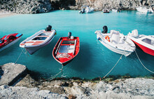 Turquoise Azure Blue Sea Water And Bright Red And White Speed Boats At Anchor. Seaside. Touristic Destination. Boat Trip. Greece Island Bay Or Lagoon