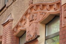 A Fragment Of The Facade Of The House Of The Late 19th Century With Stucco Molding In The Form Of A Coat Of Arms And Pattern.