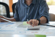 © PHAISITSAWAN - Business men use calculators and graph analysis laptops to plan marketing strategies and make profitable investments in the company.