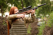 © Mallivan - A young woman shoots from a weapon