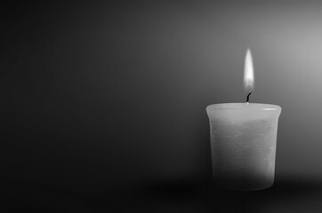 Wall Mural - Candle burning in the black background. The concept of mourn, grief or mourning