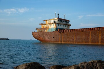 Sticker - Abandoned rusty ship on a tranquil sea captured from a rocky shore