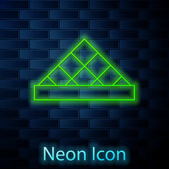 Canvas Print - Glowing neon line Louvre glass pyramid icon isolated on brick wall background. Louvre museum. Vector