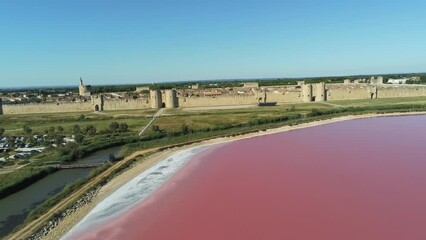 Wall Mural - Etang d'eau salée rose devant la forteresse de Aigues-Mortes, vue aérienne, Occitanie