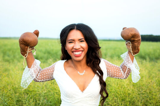 beautiful african-american bride posing with boxing gloves