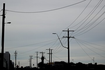 Sticker - A silhouette of power lines on a dark gloomy day