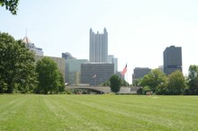 Green Lawn Surrounded By Trees The Backdrop Of The One PPG Place Skyscraper In Pittsburgh.USA