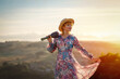 © Iryna - woman in a dress and a hat with a lavender bouquet in her hands on a hill in summer sunset
